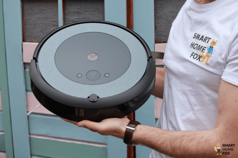 A robot vacuum cleaner is held up to see.